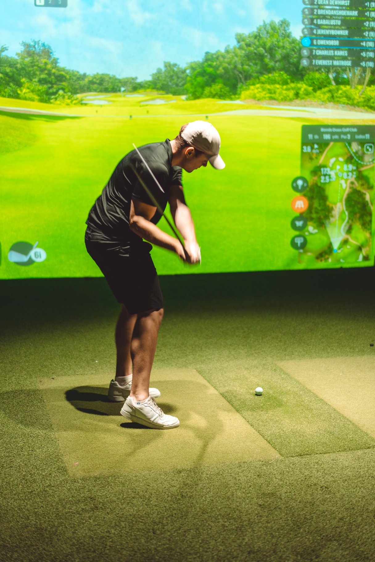 Golfer playing a hole on the GolfSpace course simulator.