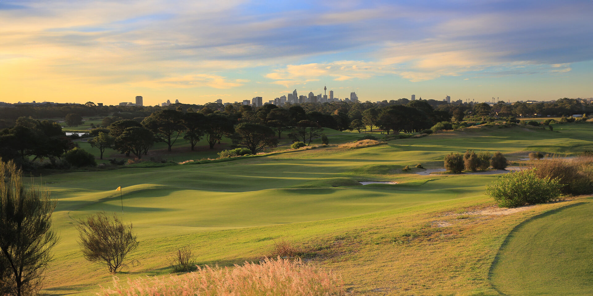 Bonnie Doon Golf Club fairway at golden hour with the Sydney skyline behind